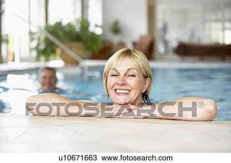 Stock Image - Middle Aged Couple In Swimming Pool. Fotosearch