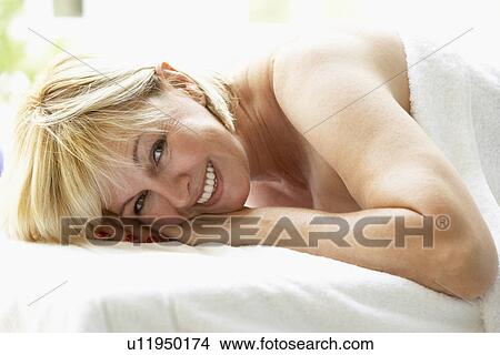 Picture - Middle Aged Woman Relaxing On Massage Table. Fotosearch