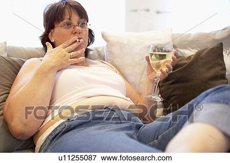 Stock Photo - Overweight Woman Relaxing On Sofa. Fotosearch
