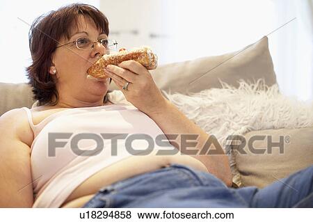 Stock Photo - Overweight Woman Relaxing On Sofa. Fotosearch