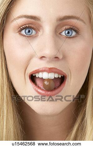 Stock Photo - Portrait Of Young Woman Eating Chocolate. Fotosearch