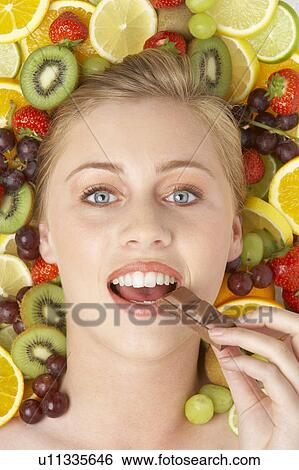 Stock Photograph - Portrait Of Young Woman Eating Chocolate. Fotosearch