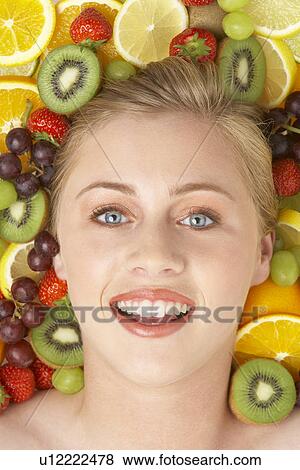 Stock Photo - Portrait Of Young Woman Surrounded By Fruit. Fotosearch