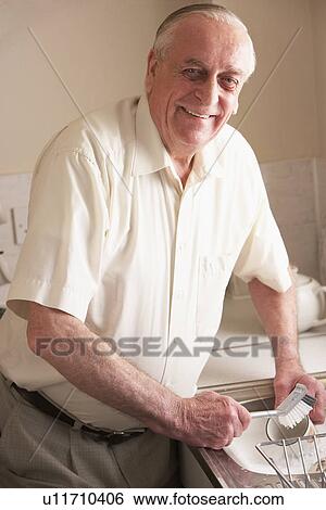 Stock Photograph - Senior Man Washing Up At Sink. Fotosearch