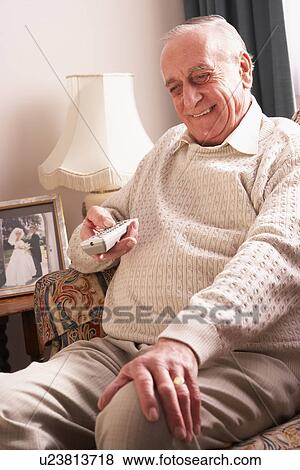 Stock Photo - Senior Man Watching TV At Home. Fotosearch
