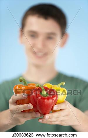 Stock Image - Teenage Boy Holding Fresh Peppers. Fotosearch