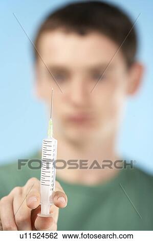 Stock Image - Teenage Boy Holding Syringe. Fotosearch