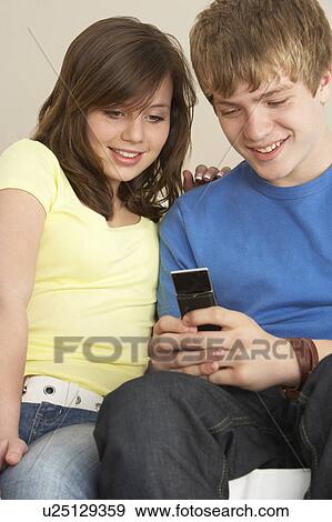 Teenage Couple Reading Text Message View Large Photo Image Stock Photo - Teenage Couple Reading Text Message. Fotosearch