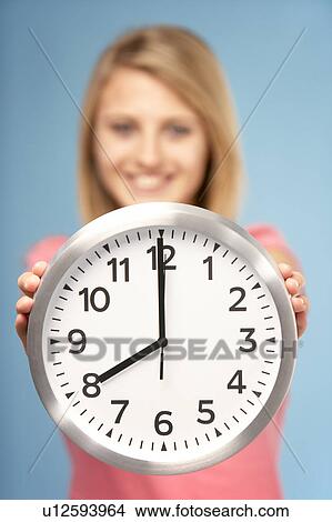 Picture - Teenage Girl Holding Clock. Fotosearch