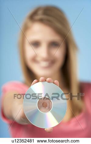 Stock Image - Teenage Girl Holding DVD. Fotosearch