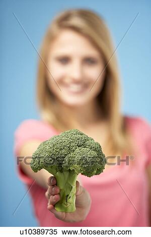Stock Photography - Teenage Girl Holding Fresh Broccoli. Fotosearch