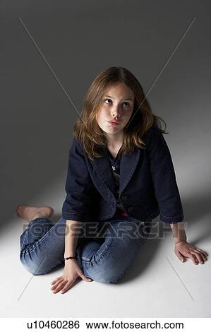 Stock Photograph - Thoughtful Girl Sitting In Studio. Fotosearch