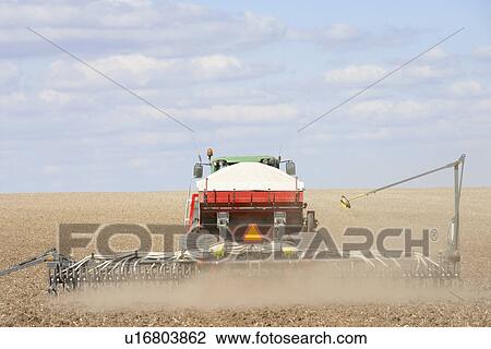 Stock Image - Tractor Planting Seed In Field. Fotosearch