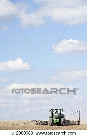 Stock Photo - Tractor Planting Seed In Field. Fotosearch