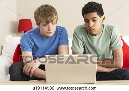 Stock Photograph - Two Boys Using Laptop At Home. Fotosearch