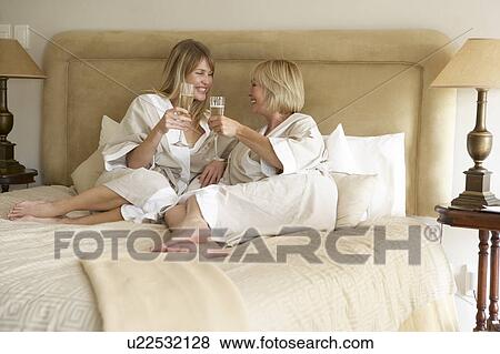 Two Women Enjoying Champagne In Bedroom View Large Photo Image Stock Photo - Two Women Enjoying Champagne In Bedroom. Fotosearch