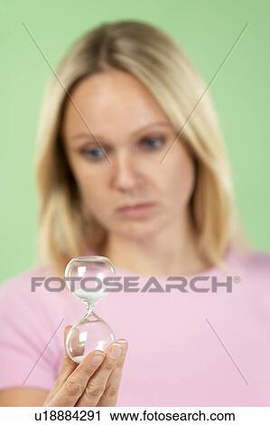 Stock Image - Woman Holding Hourglass. Fotosearch