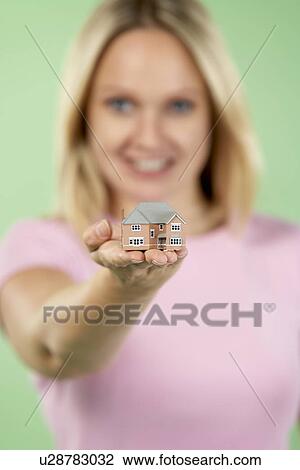 Stock Image - Woman Holding Model House. Fotosearch