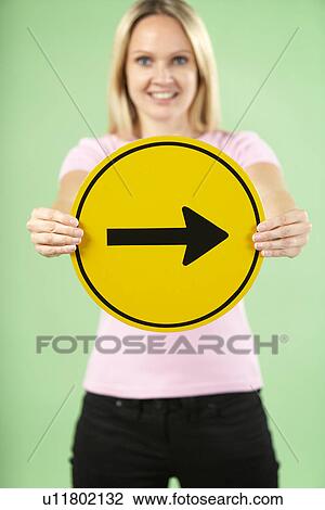 Stock Image - Woman Holding Road Traffic Sign. Fotosearch