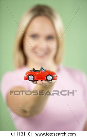 Stock Image - Woman Holding Toy Car. Fotosearch