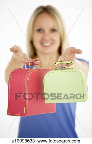 Stock Image - Woman Holding Two Suitcases. Fotosearch