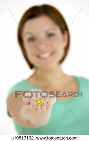 Stock Image - Woman Holding Vitamin Capsules. Fotosearch