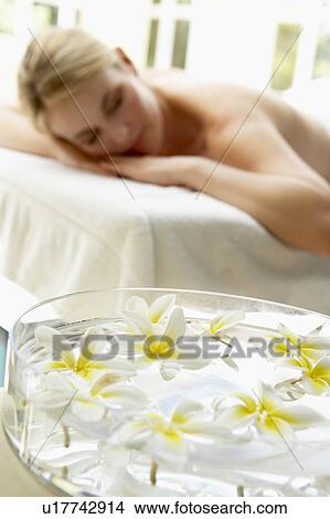 Picture - Woman On Massage Table With Flowers In Foreground. Fotosearch