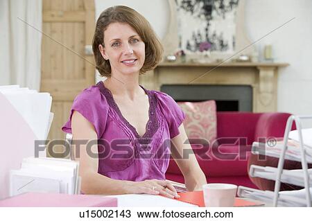 Woman sitting at her desk View Large Photo Image Stock Image - Woman sitting at her desk. Fotosearch
