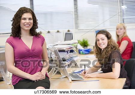 Women happily working in an office View Large Photo Image Stock Photo - Women happily working in an office. Fotosearch