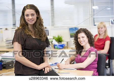 Women working happily in an office View Large Photo Image Stock Photograph - Women working happily in an office. Fotosearch