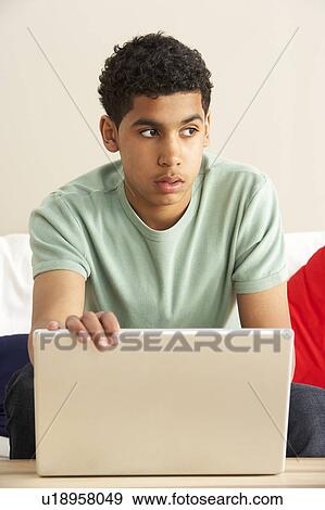 Stock Photo - Worried Looking Boy Using Laptop. Fotosearch