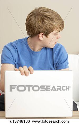 Stock Photograph - Worried Looking Boy Using Laptop. Fotosearch