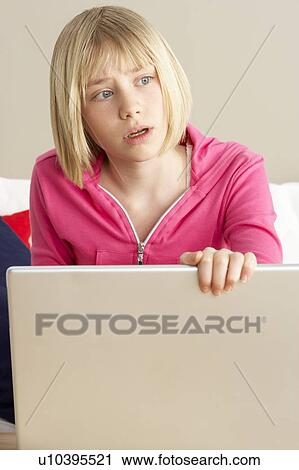 Stock Image - Worried Looking Girl Using Laptop. Fotosearch