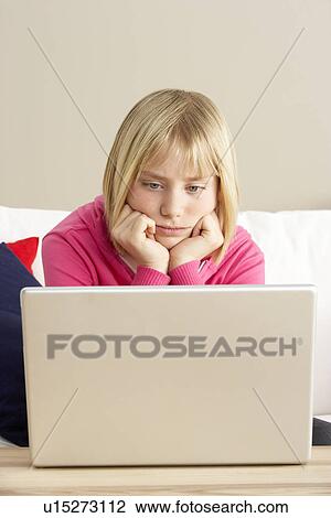 Stock Image - Worried Looking Girl Using Laptop. Fotosearch
