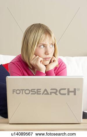 Stock Photo - Worried Looking Girl Using Laptop. Fotosearch