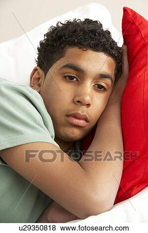 Young Boy Looking Sad On Sofa View Large Photo Image Stock Photo - Young Boy Looking Sad On Sofa. Fotosearch