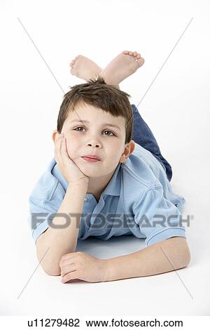 Stock Image - Young Boy Lying On Stomach In Studio. Fotosearch