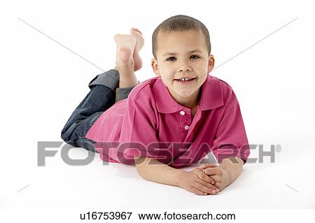 Stock Photo - Young Boy Lying On Stomach In Studio. Fotosearch