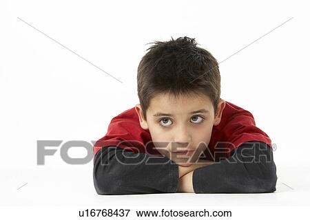Stock Photo - Young Boy Lying On Stomach In Studio. Fotosearch