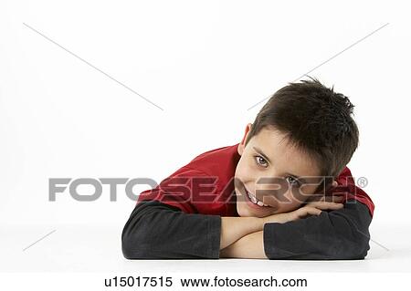 Young Boy Lying On Stomach In Studio View Large Photo Image Stock Photography - Young Boy Lying On Stomach In Studio. Fotosearch