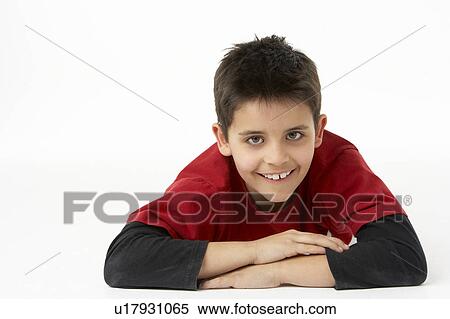 Stock Photography - Young Boy Lying On Stomach In Studio. Fotosearch