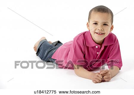 Stock Photography - Young Boy Lying On Stomach In Studio. Fotosearch