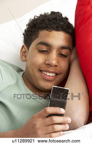 Stock Image - Young Boy Reading Text Message. Fotosearch