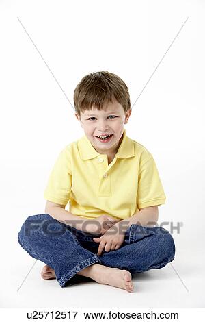 Stock Photo - Young Boy Sitting In Studio. Fotosearch