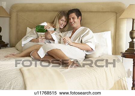 Young Couple Enjoying Champagne In Bedroom View Large Photo Image Stock Photography - Young Couple Enjoying Champagne In Bedroom. Fotosearch