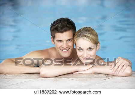 Stock Image - Young Couple Swimming In Pool. Fotosearch