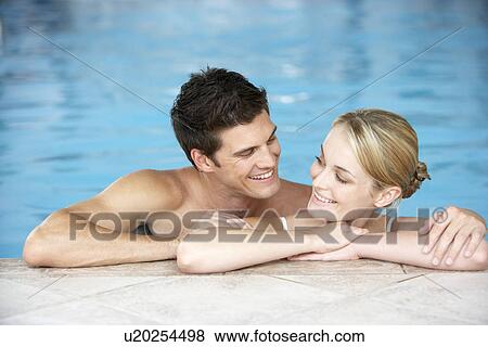 Stock Photo - Young Couple Swimming In Pool. Fotosearch