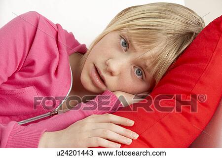 Stock Image - Young Girl Looking Sad On Sofa. Fotosearch