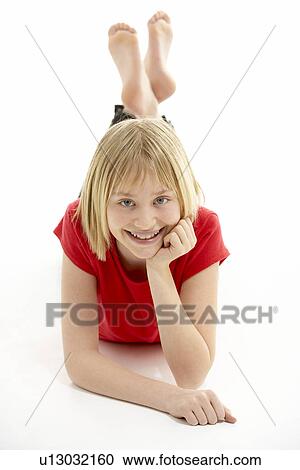 Stock Image - Young Girl Lying On Stomach In Studio. Fotosearch