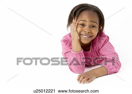 Stock Image - Young Girl Lying On Stomach In Studio. Fotosearch